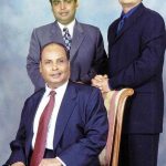 मुकेश अंबानी अपने पिता धीरूभाई अंबानी (बैठे हुए) और भाई अनिल अंबानी के साथ 
