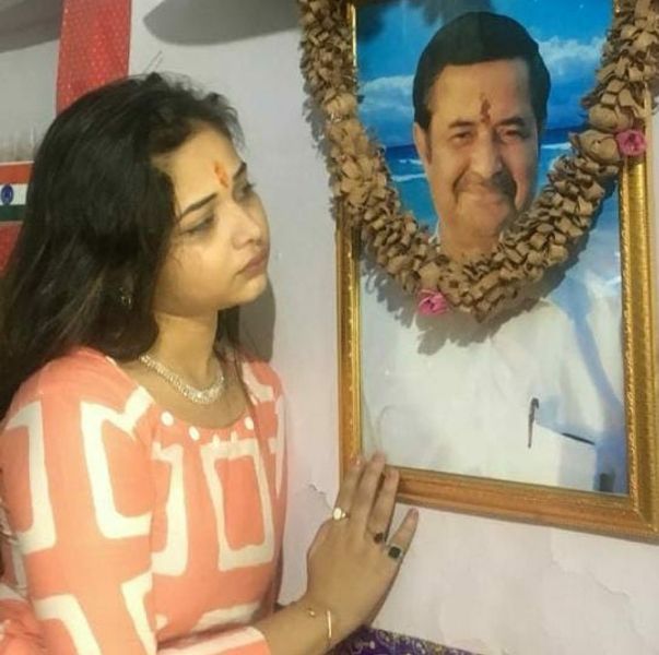 Sneh Upadhya looking at her father Chandra Prakash Upadhya's portrait