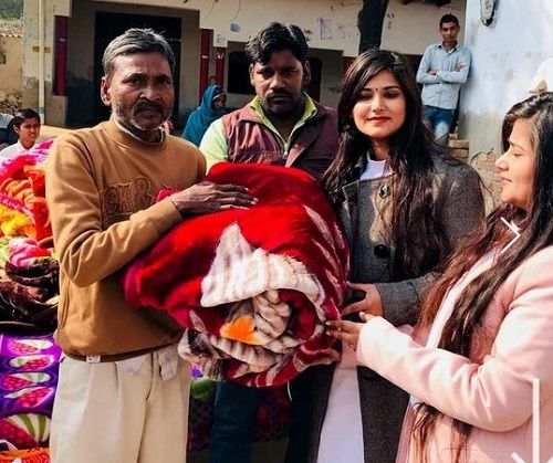 Devi Nidhi Saraswat and Devi Neha Saraswat donating blankets