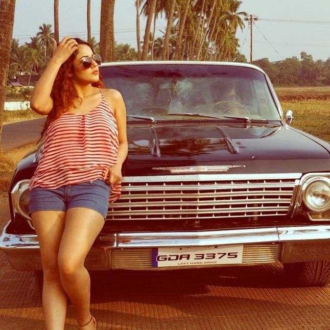 Shehnaz Kaur Gill posing with a car