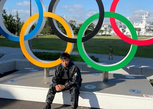 Shushila Likmabam posing in front of the Olympic rings in Tokyo