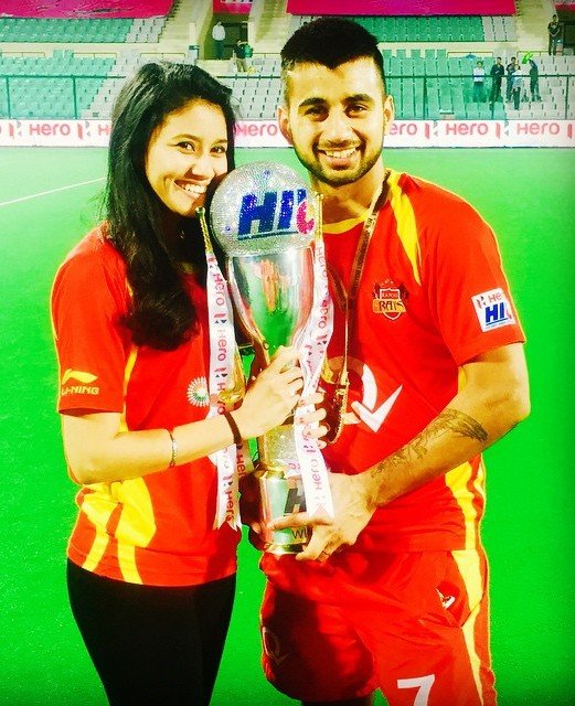 Manpreet Singh posing with the Hero Hockey India League trophy, along with Illi Najwa Saddique